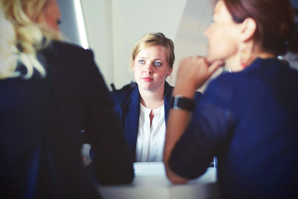 drei Frauen sitzen neben Tisch