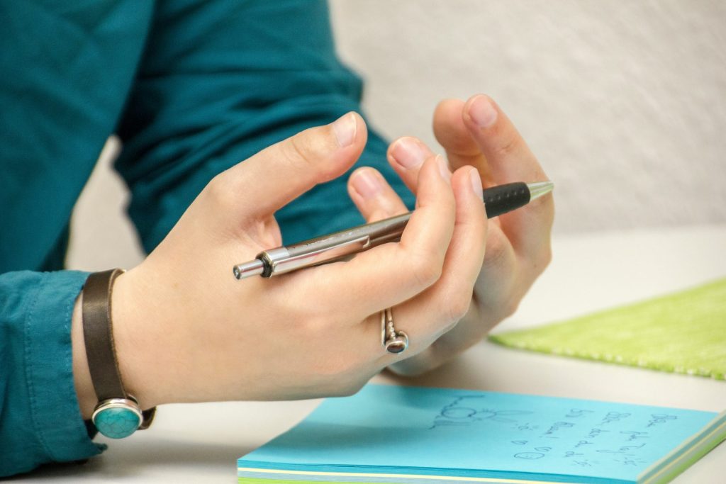 eine Person, die an einem Tisch sitzt und ein Mobiltelefon benutzt